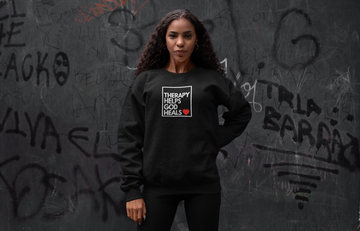Woman wearing a graphic sweatshirt against a graffiti wall